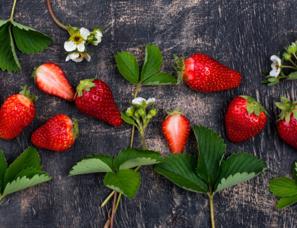 Fresh ripe strawberry with leaves and flowers. Top view